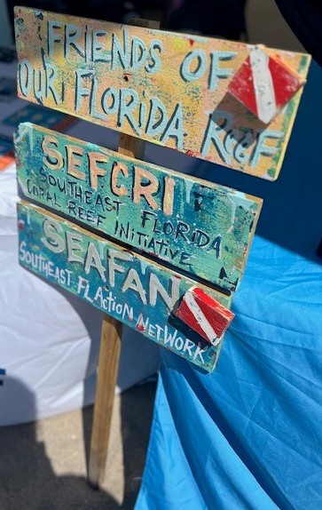Support organizations' names painted on a wooden sign.